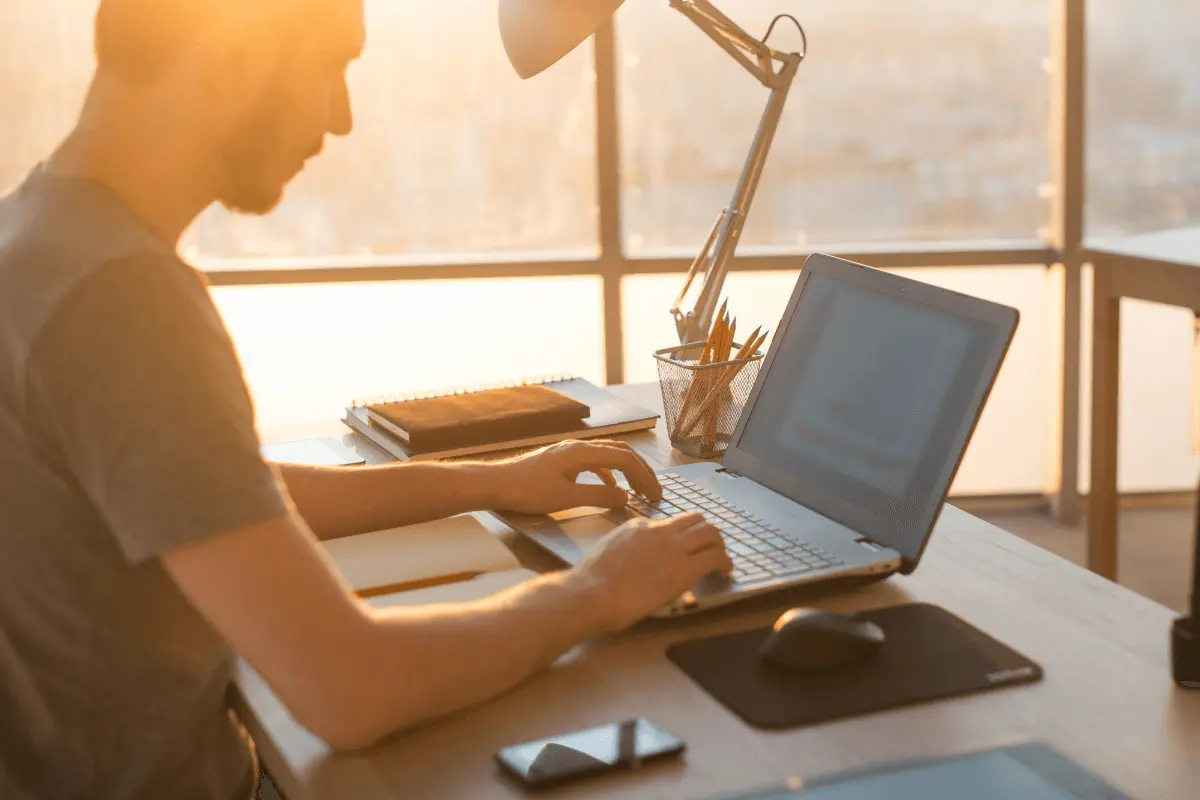 a man typing on his laptop