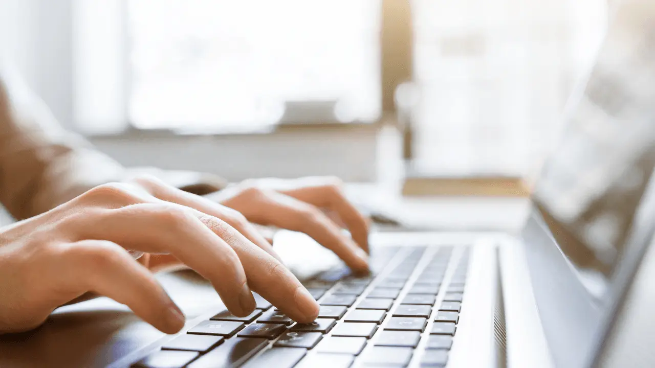 A person typing on a laptop.