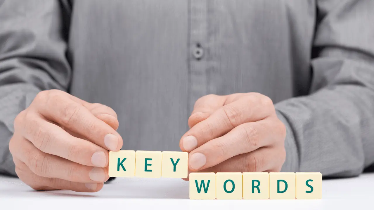 Person Holding Blocks With Letters On Spelling out Key Words.