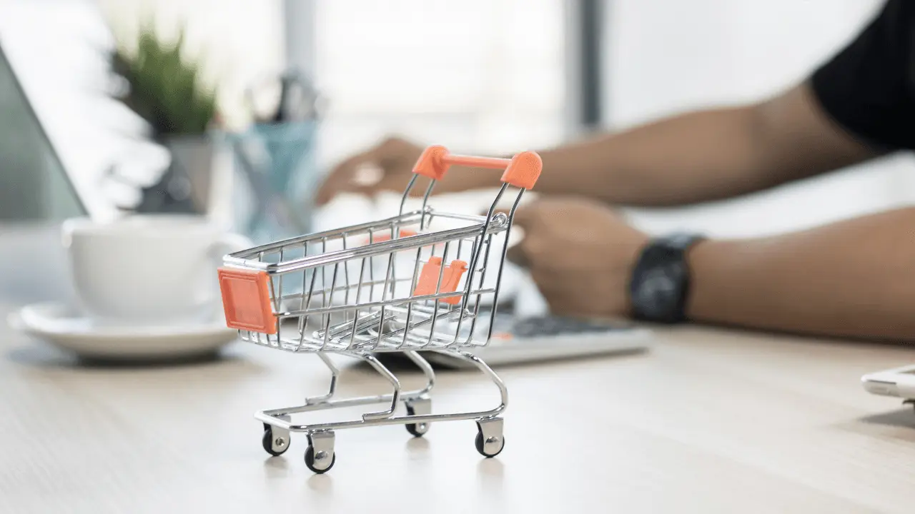 A retail trolley figure and a person on a laptop.