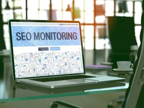 Laptop displaying SEO monitoring dashboard in a modern office